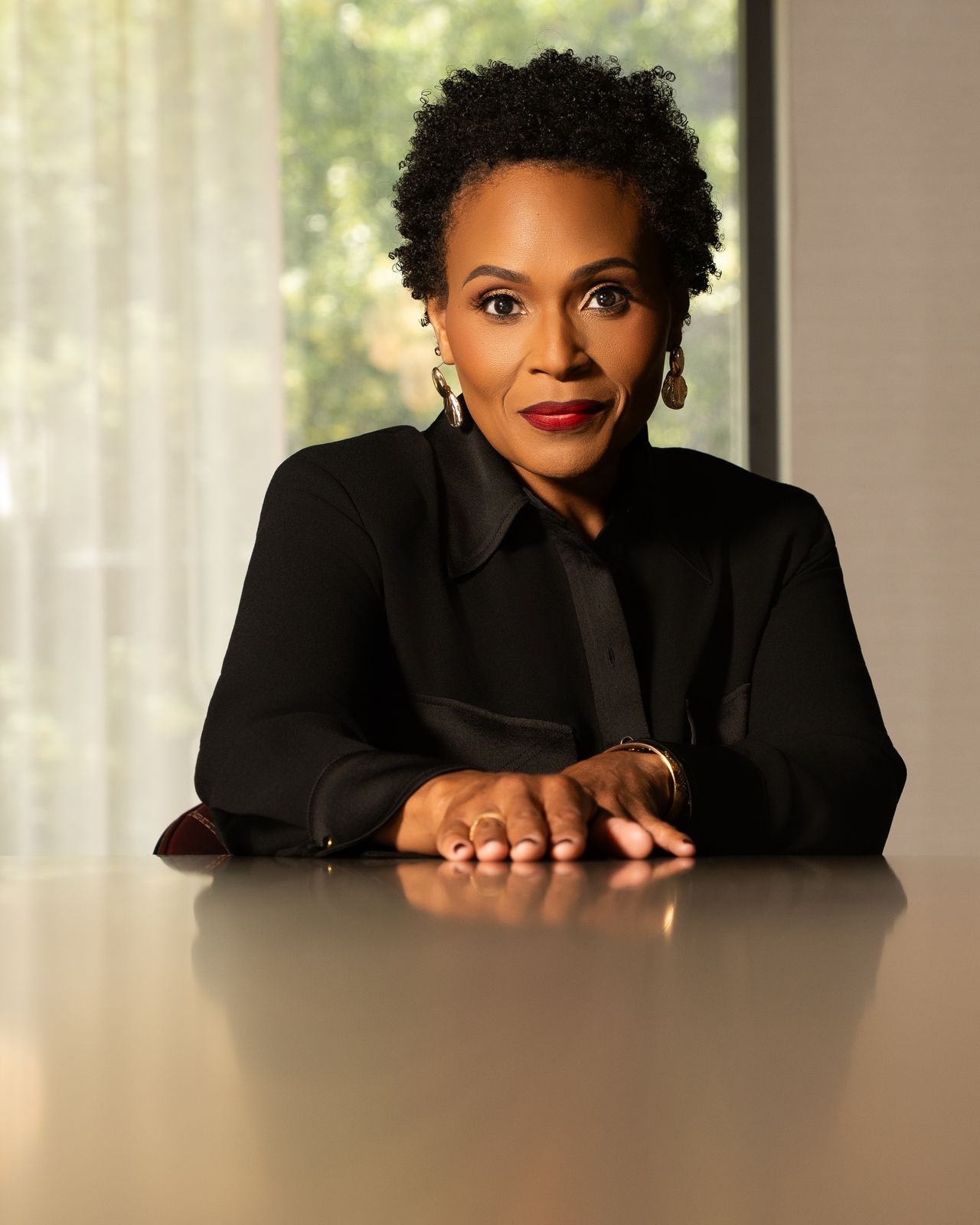 Cynthia Barnes, seated at a boardroom table.
